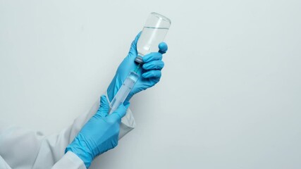 Wall Mural - A nurse draws liquid with a syringe from a bottle.