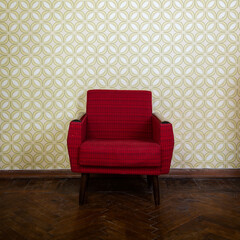 vintage room with old fashioned red armchair, wallpaper and weathered wooden parquet floor