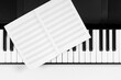 Music learning background. Piano keyboard and music sheet notebook. Top view