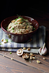 Wall Mural - Kidney bean paste or appetizer with walnut and fried onion in a bowl on linen textile on dark black moody background, closeup, copy space, vegan and lenten food concept