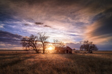 An Old Farmhouse On The Eastern Plains Of Colorado In A Rural Setting At Sunset. The Sky Is Dramatic With Wispy Clouds. The Old House If Falling Apart And Abandoned. 