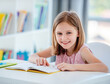 © tan4ikk - Schoolgirl with textbook sitting at desk