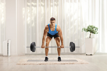 Wall Mural - Strong young man in sportswear doing weightlifting