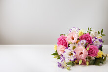 Mock Up Bouquet Of Roses, Daisies, Lisianthus, Chrysanthemums, Unopened Buds On A White Table And Wall.