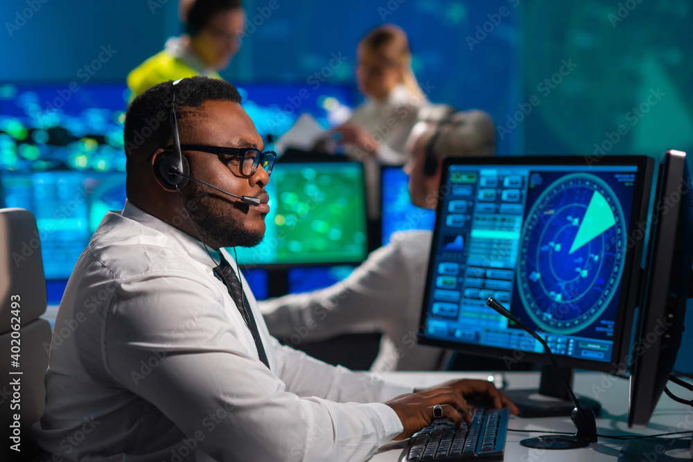Workplace of the air traffic controllers in the control tower. Diverse team of aircraft control officers works using radar, computer navigation and digital maps. Aviation concept. - obrazy, fototapety, plakaty 