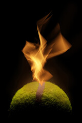 Wall Mural - A vertical shot of a tennis ball with flames of fire