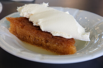 A closeup shot of delicious Turkish desert ekmek kadayifi on a white plate