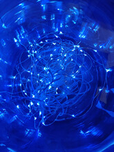 A Vertical Closeup Of Blue LED Lights In A Glass Jar In A Dark Room