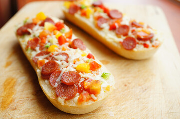 A top view closeup of two delicious salami baguettes on a wooden board