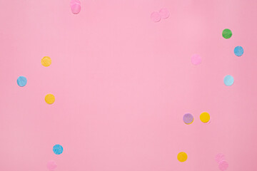 Wall Mural - Colorful confetti on pink background with copy space