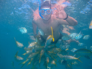 A closeup shot of male swimming with fishes