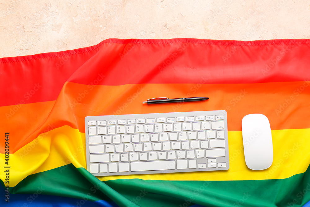 Rainbow LGBT flag, keyboard and mouse on color background