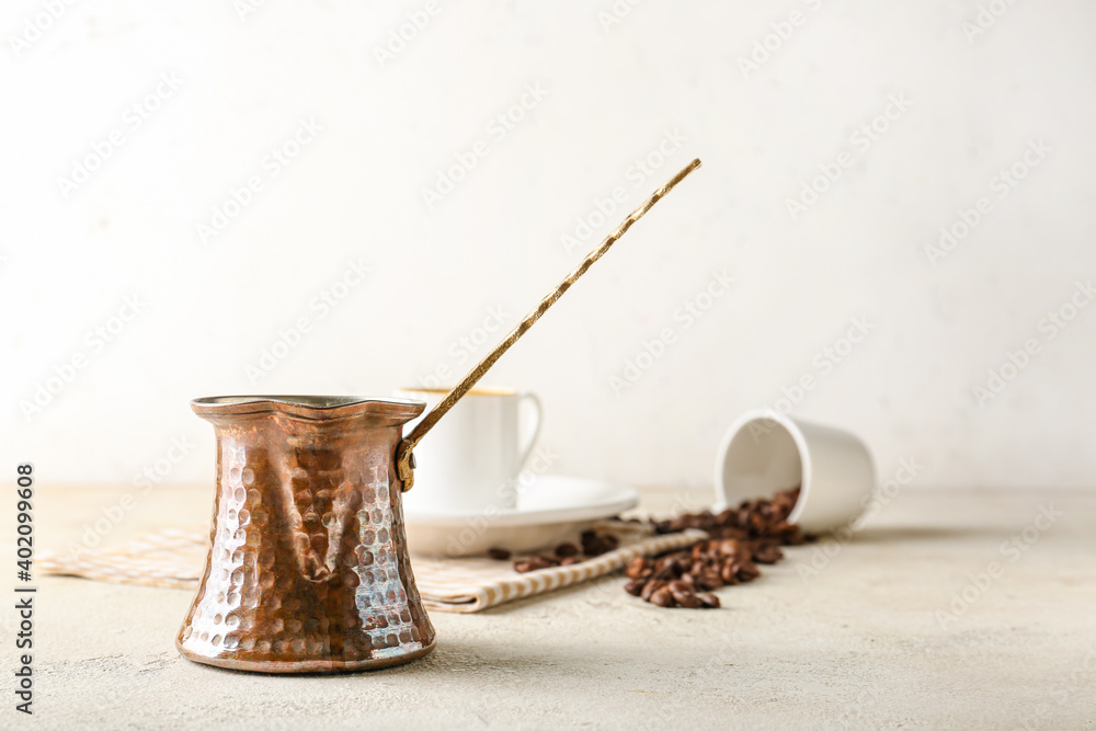 Cezve with hot aromatic coffee on table