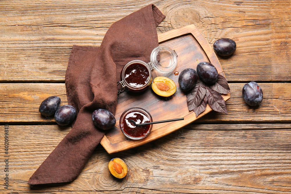 Composition with delicious homemade plum jam on wooden background
