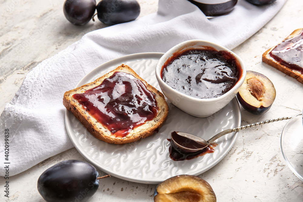 Slice of bread with delicious homemade plum jam on table