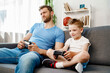 © fotofabrika - Father and his little son playing video games together at home