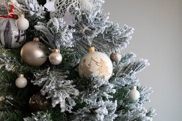 Close up of balls on christmas tree. Blurred gray background. New Year concept.