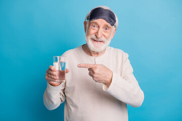 Poster - Photo portrait of old man in eye mask pointing finger at water glass isolated on pastel blue colored background