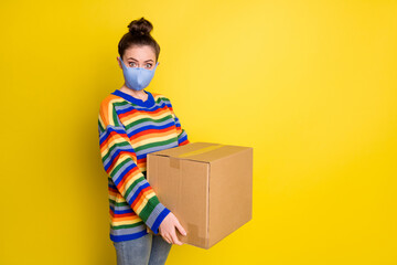 Sticker - Photo of brunette girl hold huge box wear blue mask from corona rainbow sweater pants isolated on bright yellow color background