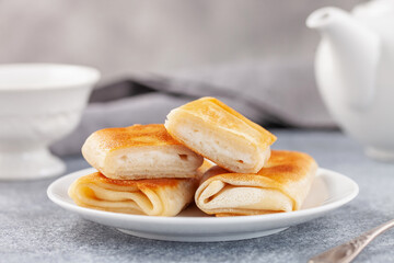 Wall Mural - Pancakes envelopes with cottage cheese, curd or ricotta in a plate on a grey background