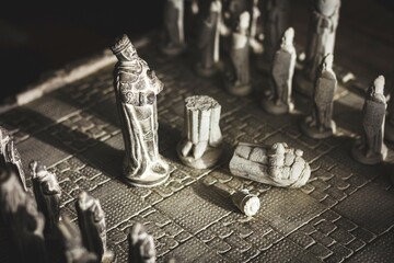 Wall Mural - A portrait of a king of a game of chess, who destroyed the other army king. The chessboard and its pieces are made of stone sculptures and the white king is broken into pieces.