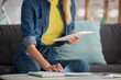 © LIGHTFIELD STUDIOS - Cropped view of woman with digital tablet sitting near notebook at home on blurred background
