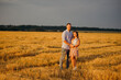 © vitleo - A happy couple in a field in the rays of the setting sun