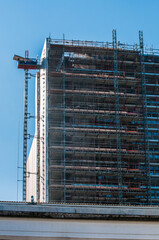 building under construction with crane lifting loads