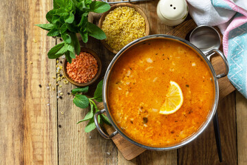 Turkish cuisine. Traditional soup with rice, lentils and mint on a rustic table. Top view flat lay. Copy space.