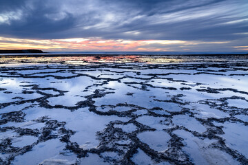 Poster - beautiful sunset over the ocean with rocky beach and tidal pools in the foreground