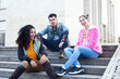 © iordani - cute group of teenages at the building of university with books huggings, diversity nations real students lifestyle