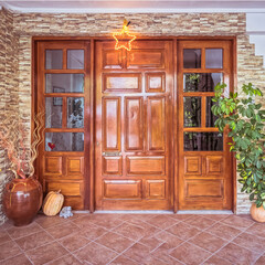 Christmas decorated house front with natural wood and glass entrance door