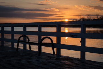 Zegrze, Poland - March 13, 2020: A pier on Lake Zegrzyński, a surface of water in the rays of the rising sun. Spring at the lake.