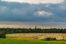 Dense, Grey Clouds Over A Farmer's Field-collected With Hay Bales