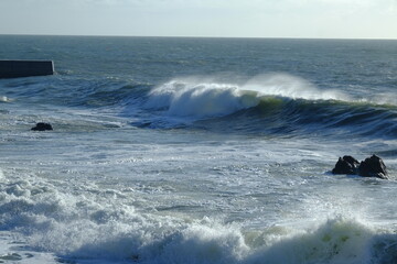 A big wave breaking in the small harbour of Batz sur mer. (West of France, december 2020)