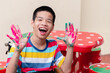 © GAYSORN - Asian disabled child on wheelchair smiling with his hands were stained with watercolor, Skills to practice muscle development,Lifestyle in education age of special kids, Happy disability kid concept.