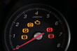 © Ethan L - Close up of tachometer dial with warning lights on a car