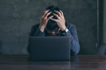 sad depression serious people from work stress concept.asian man feeling tired suffering using computer working work place.concept global economic and health problems