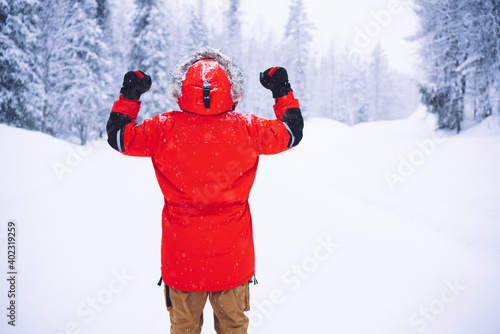 Fototapeta Unrecognizable traveler celebrating success near winter forest