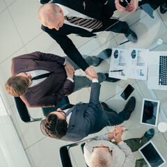 Poster - top view. financial partners confirming the transaction with a handshake.