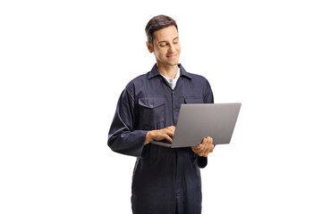 Wall Mural - Young male worker in an overall uniform with a laptop computer
