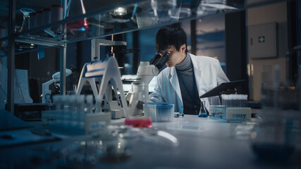 Wall Mural - medical development laboratory: east asian scientist uses digital tablet computer, looks under micro