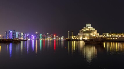 Wall Mural - A panoramic view of the old dhow harbour night timelapse hyperlapse in Doha, Qatar, with the West Bay skyline in the background. Modern skyscrapers and museum on background and old boats on foreground