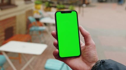 Slow motion hands man using phone with vertical green screen background terrace city blurred internet chrome outdoor. Cellphone media device. Close up