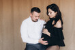 © Олег Блохин - Pregnancy photo session in a photo studio with a fabric background in a black bodysuit and tights