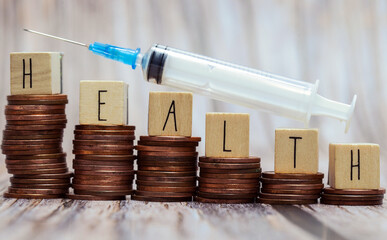 Word HEALTH on step stacked coins with syringe for injection, Money savings or investment planning for life insurance and healthcare concept.