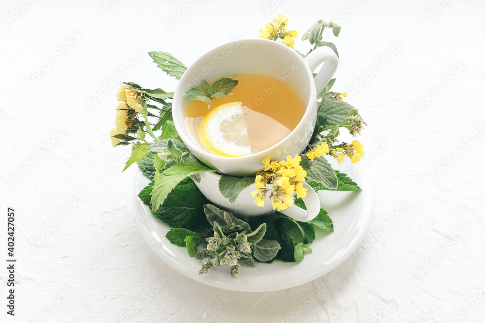 Cup with herbal tea on light background