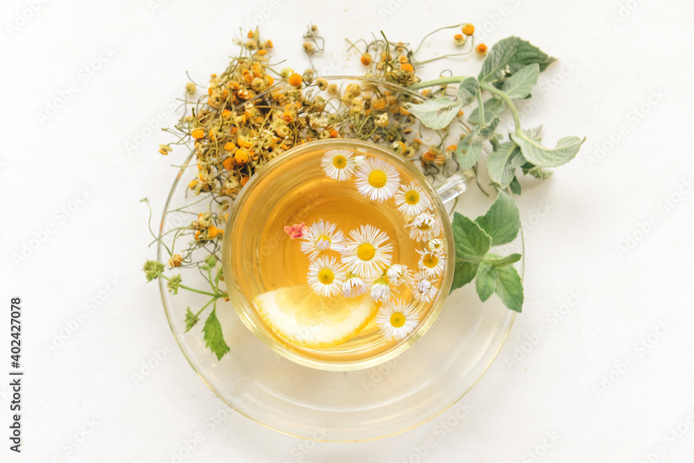 Cup with herbal tea on light background