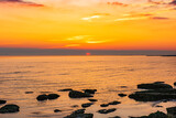 Fototapeta Desenie - Colorful sunrise on the rocky sea coast