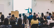 © kasto - Speaker Giving a Talk at Business Meeting. Audience in the conference hall. Business and Entrepreneurship. Focus on unrecognizable people from rear.